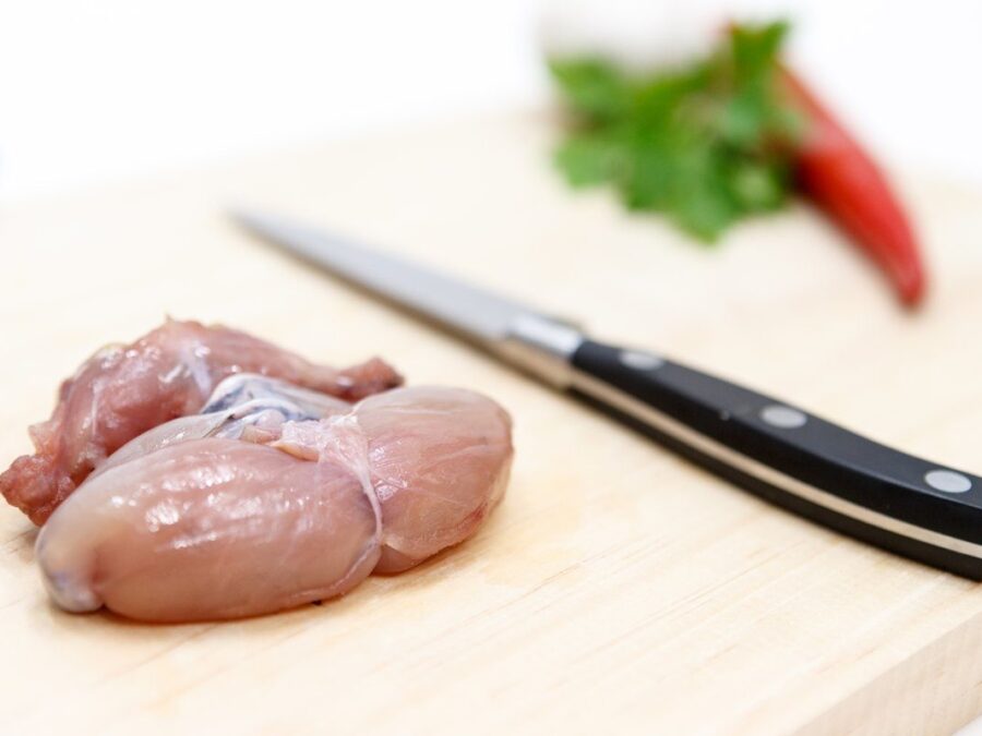 Cuisses de grenouille crues sur une planche, avant cuisson